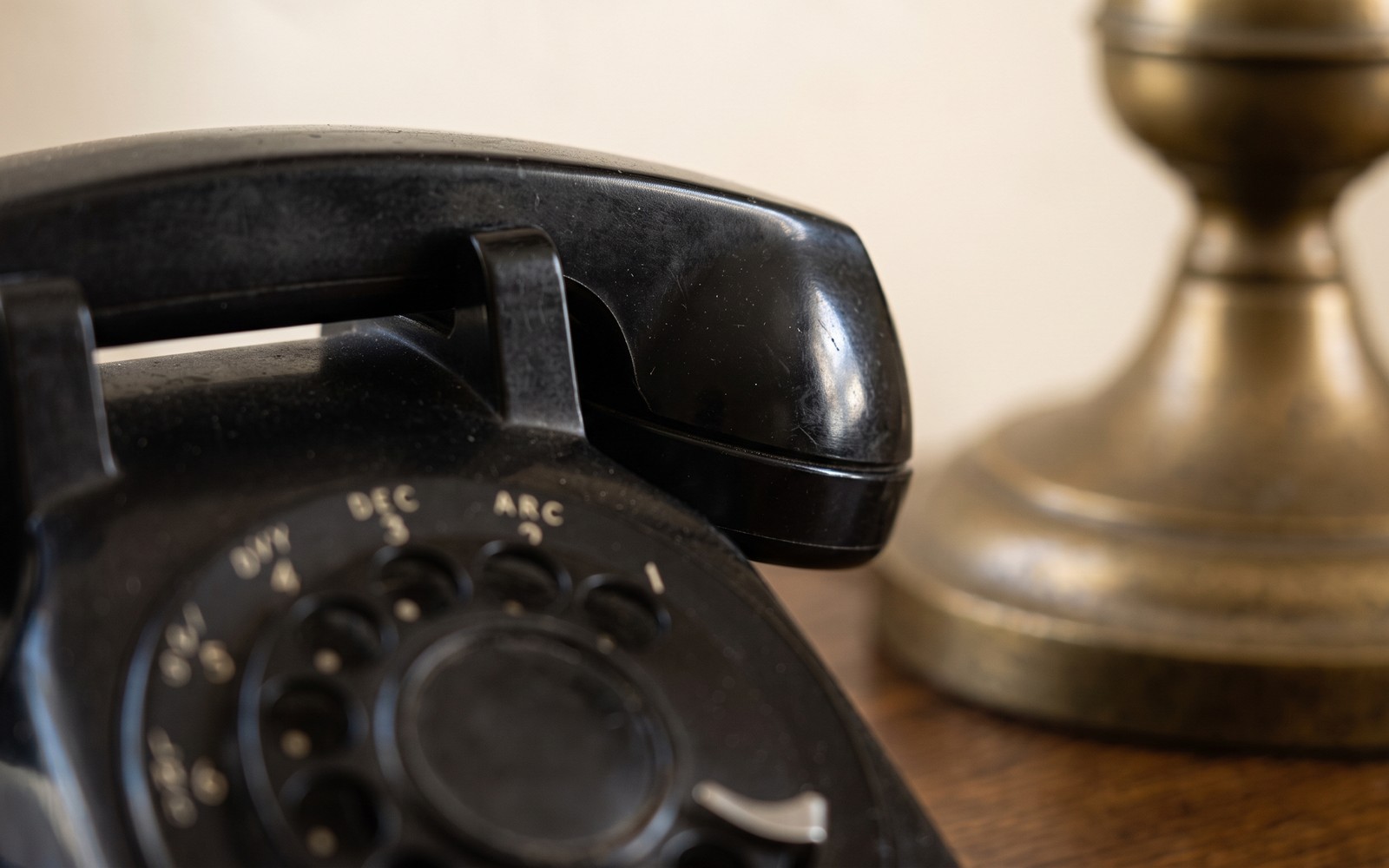 Desk telephone beside a brass lamp